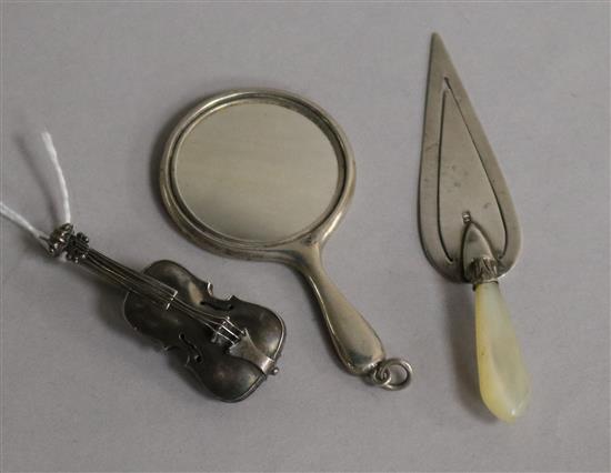 A late Victorian silver violin brooch, a silver trowel book mark and a small silver handbag mirror.